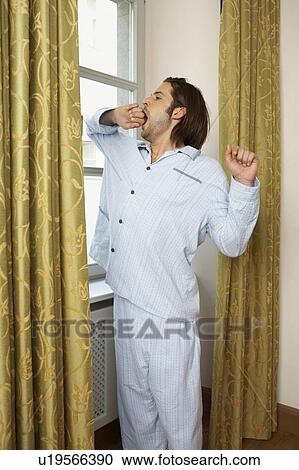 young man wearing pyjamas standing stretching and yawning View Large Photo Image Stock Image - young man wearing pyjamas standing stretching and yawning. Fotosearch