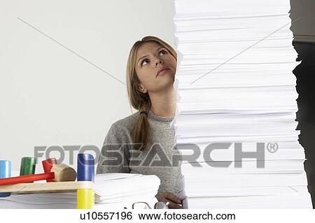 Young woman working from home with huge pile of paper. View Large Photo Image Stock Photograph - Young woman working from home with huge pile of paper.. Fotosearch