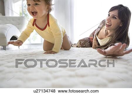 Baby first crawls, mother watches View Large Photo Image Stock Photo - Baby first crawls, mother watches. Fotosearch