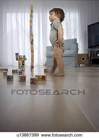Baby standing, watching cube tower View Large Photo Image Stock Photo - Baby standing, watching cube tower. Fotosearch