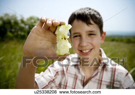 Stock Photo - Boy holding up apple core. Fotosearch