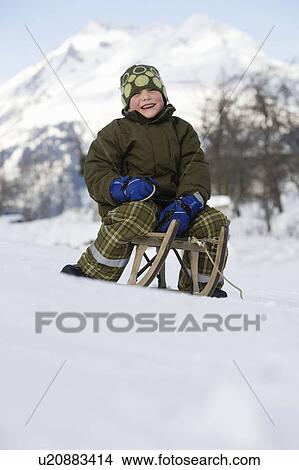 Picture - Boy on sitting sledge. Fotosearch