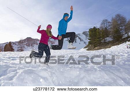 Stock Image - Couple at ski, jumping. Fotosearch