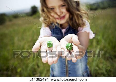 Picture - Girl holding dice. Fotosearch