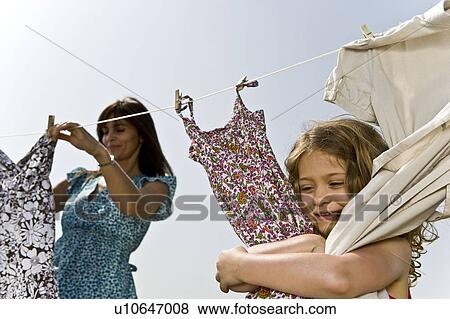 Stock Photo - Girl hugging clothes on line. Fotosearch