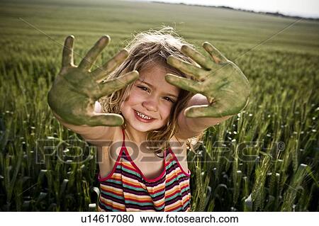 Stock Image - Girl with painted green hands. Fotosearch