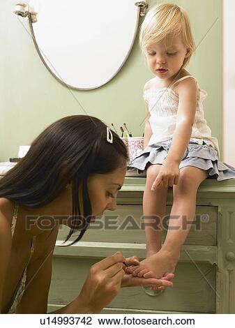 Stock Image - Mother and daughter applying makeup.. Fotosearch