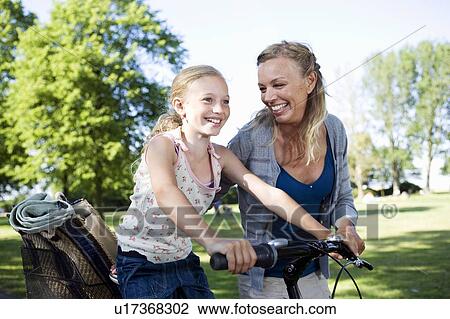 Stock Image - Mother and daughter with bike. Fotosearch