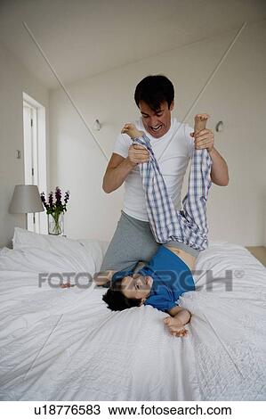Stock Image - Portrait of a father and son playing.. Fotosearch