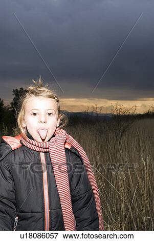 Stock Photo - Portrait of a girl in a field.. Fotosearch