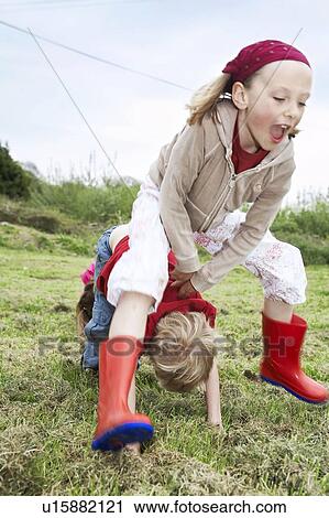 Two children playing leapfrog View Large Photo Image Stock Image - Two children playing leapfrog. Fotosearch