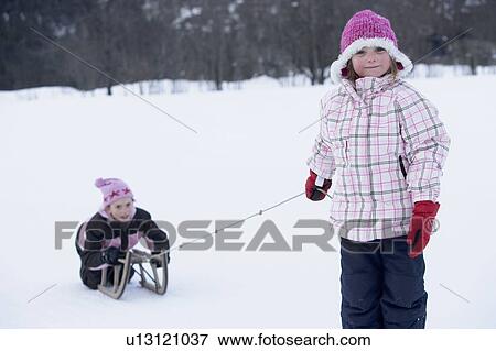 Young girls playing with sledge View Large Photo Image Stock Photo - Young girls playing with sledge. Fotosearch