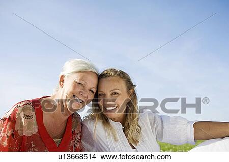 Picture - 2 generations sitting together. Fotosearch