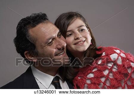Stock Image - Businessman and daughter (9-11) smiling, close-up. Fotosearch