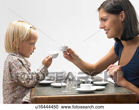 Stock Image - Daughter and mother having tea. Fotosearch