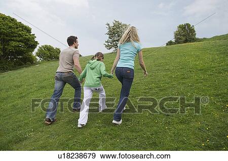 Stock Photo - Family walk up hill. Fotosearch