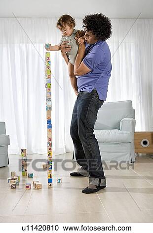 Stock Image - Father holding baby. Fotosearch