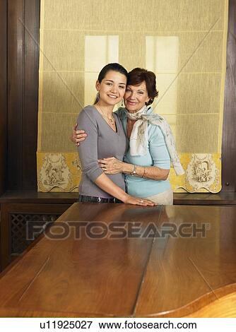 Mother and adult daughter embracing by grand piano, portrait View Large Photo Image Stock Photo - Mother and adult daughter embracing by grand piano, portrait. Fotosearch