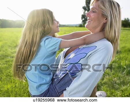 Stock Photo - Mother and daughter playing in a field.. Fotosearch