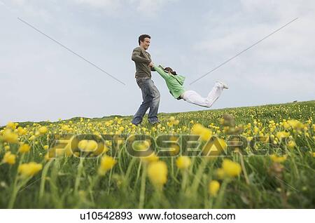 Parent swings daughter by her arms View Large Photo Image Stock Image - Parent swings daughter by her arms. Fotosearch