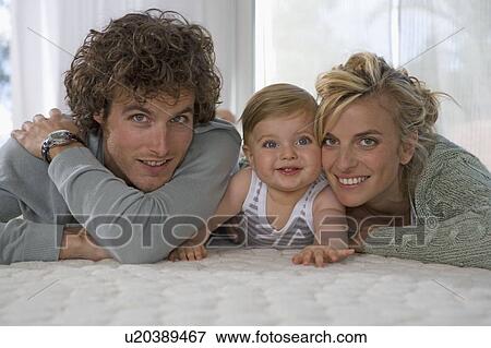 Stock Photo - Portrait happy parents with baby. Fotosearch