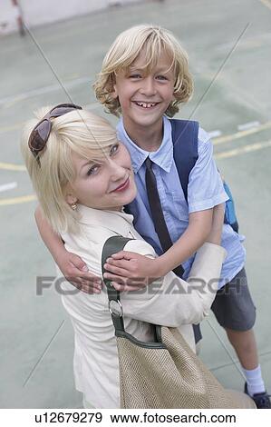 Stock Photo - School boy hugging mother. Fotosearch