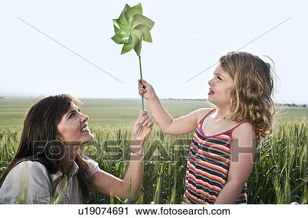 Woman and child holding toy windmill View Large Photo Image Stock Image - Woman and child holding toy windmill. Fotosearch