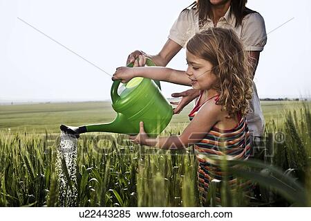 Woman and child with watering can View Large Photo Image Stock Photography - Woman and child with watering can. Fotosearch