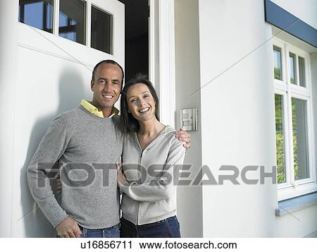 Couple in front of a house, smiling View Large Photo Image Stock Image - Couple in front of a house, smiling. Fotosearch