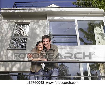 Stock Photo - Couple on a terrace, smiling. Fotosearch