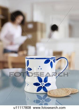 Cup and biscuits on office table View Large Photo Image Stock Photo - Cup and biscuits on office table. Fotosearch