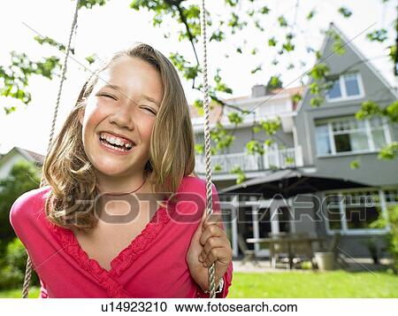 Girl on a swing smiling View Large Photo Image Stock Image - Girl on a swing smiling. Fotosearch