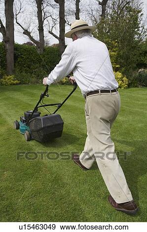 Man mows garden lawn View Large Photo Image Stock Photo - Man mows garden lawn. Fotosearch