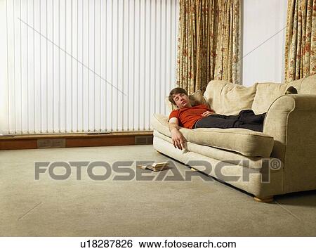 Stock Photograph - Man sleeping on sofa. Fotosearch
