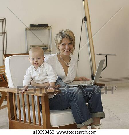 Mother sitting at laptop with young son View Large Photo Image Stock Image - Mother sitting at laptop with young son. Fotosearch