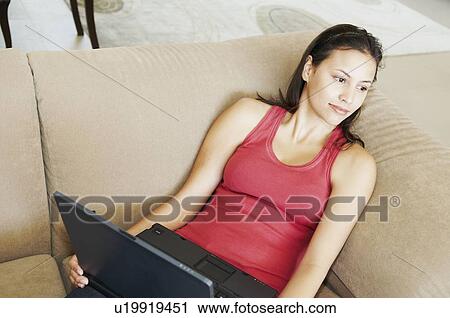 Stock Image - Reclining woman looks into mid-distance. Fotosearch