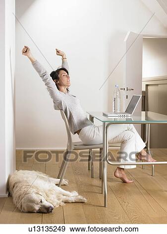 Woman at her desk, dog sleeping View Large Photo Image Stock Photo - Woman at her desk, dog sleeping. Fotosearch