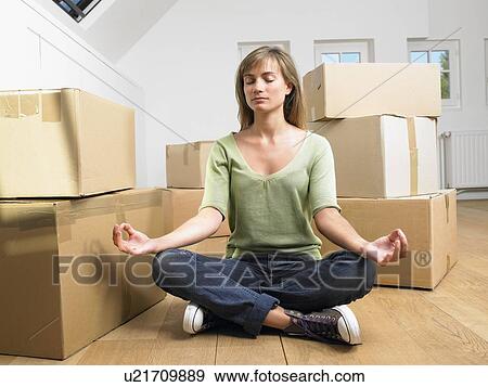 Woman doing yoga with moving boxes around her. View Large Photo Image Stock Photo - Woman doing yoga with moving boxes around her.. Fotosearch