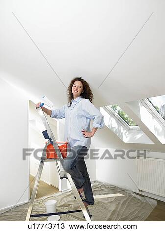 Woman painting a wall View Large Photo Image Stock Image - Woman painting a wall. Fotosearch
