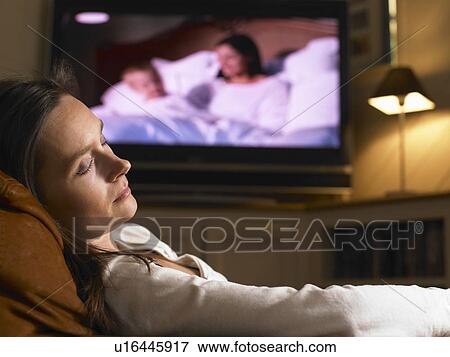 Stock Photo - Woman sleeping in front television. Fotosearch