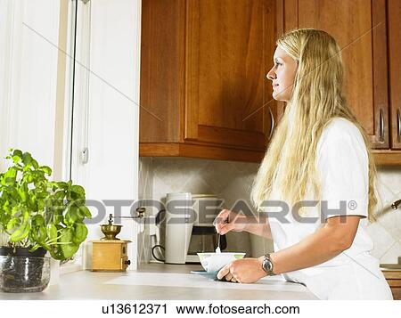 Woman standing with cup of tea in kitchen. View Large Photo Image Stock Image - Woman standing with cup of tea in kitchen.. Fotosearch