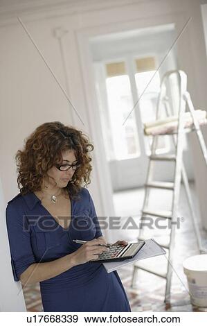 Woman using calculator in room View Large Photo Image Stock Photo - Woman using calculator in room. Fotosearch