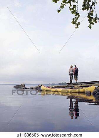 Couple holding hands on a dock near a boat. View Large Photo Image Stock Photography - Couple holding hands on a dock near a boat.. Fotosearch