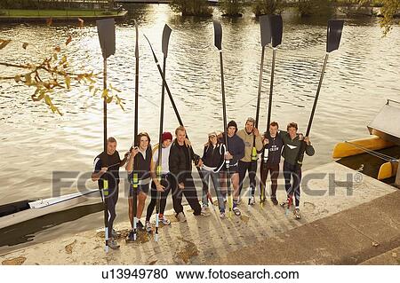 Crew on river bank holding blades. View Large Photo Image Stock Image - Crew on river bank holding blades.. Fotosearch