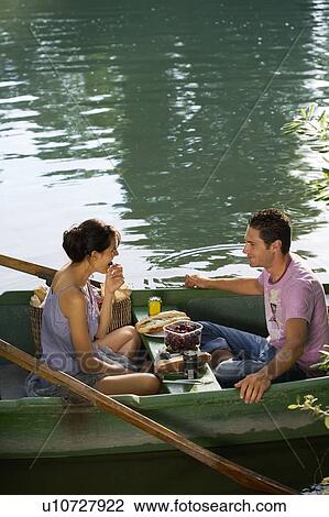 Man and woman having a picnic on boat View Large Photo Image Stock Image - Man and woman having a picnic on boat. Fotosearch