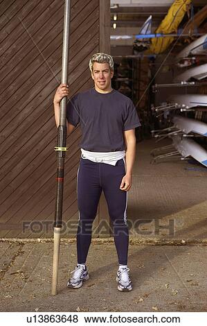 Stock Photo - Oarsman outside boat shed.. Fotosearch