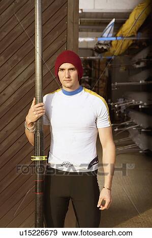 Stock Photo - Oarsman outside boat shed.. Fotosearch