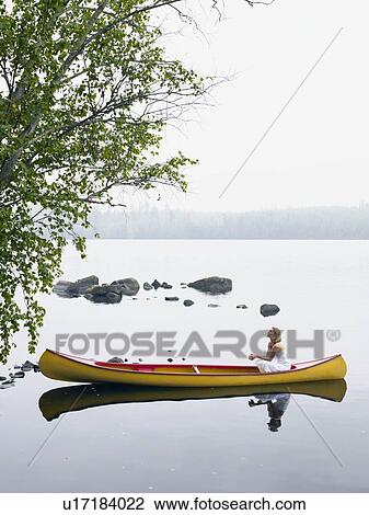 Woman sitting in a boat looking up. View Large Photo Image Stock Image - Woman sitting in a boat looking up.. Fotosearch