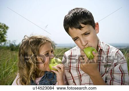 Picture - Children eating apples. Fotosearch