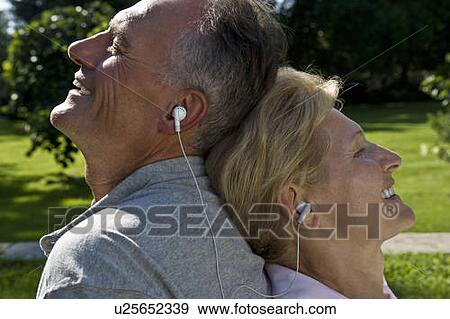 Man and woman listening to earphones View Large Photo Image Stock Photo - Man and woman listening to earphones. Fotosearch
